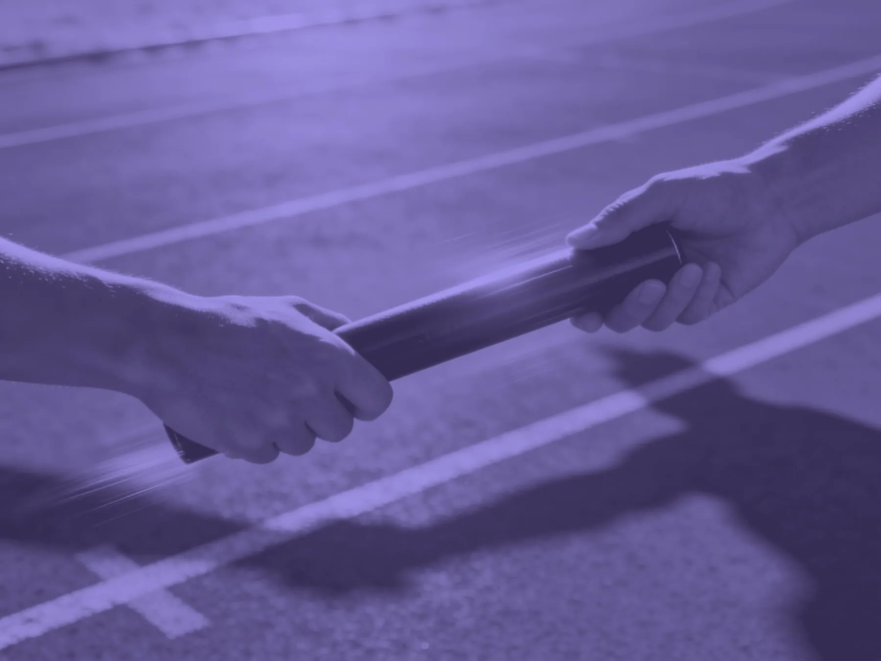 Two hands passing a relay baton on a running track
